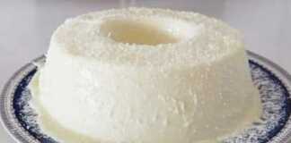 Ένα μπολ ή πιάτο με λευκή, κρεμώδη κρέμα πασπαλισμένη με άφθονο τριμμένο ινδοκάρυδο.