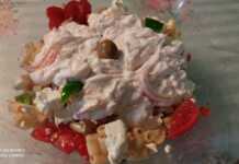 Ένα μεγάλο μπολ γεμάτο με πολύχρωμη χωριάτικη μακαρονοσαλάτα, με κοντά ζυμαρικά, κομμένες ντομάτες, πιπεριές, ελιές και θρυμματισμένη φέτα.