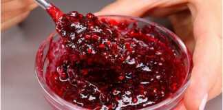 Ενα μπολ γεμάτο με κόκκινη/μωβ μαρμελάδα από διάφορα φρούτα, μερικά κομμάτια φρούτων είναι ορατά.