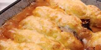 Ένα πυρέξ με ψημένες μελιτζάνες κομμένες στη μέση, γεμισμένες με κιμά και καλυμμένες με ροδοκοκκινισμένο πουρέ πατάτας και λιωμένο τυρί.