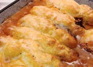 Ένα πυρέξ με ψημένες μελιτζάνες κομμένες στη μέση, γεμισμένες με κιμά και καλυμμένες με ροδοκοκκινισμένο πουρέ πατάτας και λιωμένο τυρί.