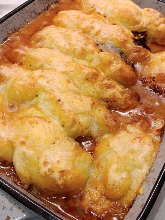 melitzanes me kima kai poure patatas Ένα πυρέξ με ψημένες μελιτζάνες κομμένες στη μέση, γεμισμένες με κιμά και καλυμμένες με ροδοκοκκινισμένο πουρέ πατάτας και λιωμένο τυρί.