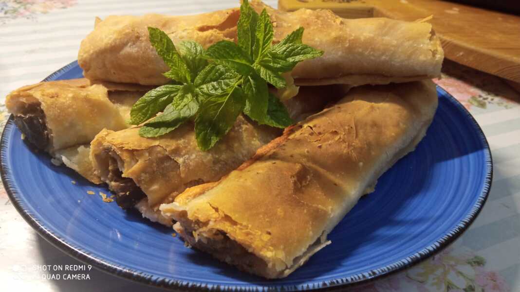 melitzanopita_lpo Ένα πιάτο με χρυσαφένια, ρολαριστά κομμάτια μελιτζανόπιτας με χειροποίητο φύλλο.