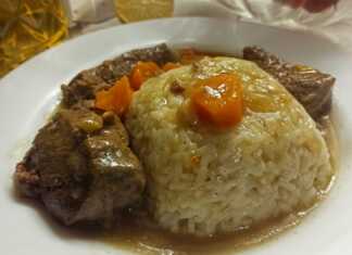 Ένα πιάτο με μαγειρεμένο μοσχάρι σε κομμάτια, περιχυμένο με μια πηχτή, καστανή σάλτσα, δίπλα σε ένα πιάτο με αφράτο πιλάφι.