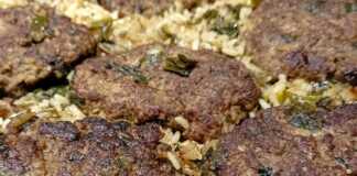 Ένα ταψί με φρεσκοψημένα, χρυσαφένια μπιφτέκια, τοποθετημένα πάνω σε αρωματικό ρύζι, έτοιμο για σερβίρισμα.