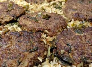 Ένα ταψί με φρεσκοψημένα, χρυσαφένια μπιφτέκια, τοποθετημένα πάνω σε αρωματικό ρύζι, έτοιμο για σερβίρισμα.