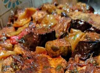 Ένα ταψί γεμάτο με πολύχρωμα ψητά λαχανικά, όπως κολοκυθάκια, μελιτζάνες, πατάτες και πιπεριές, αναμεμειγμένα με ζουμερές ροδισμένες πανσέτες χοιρινό.