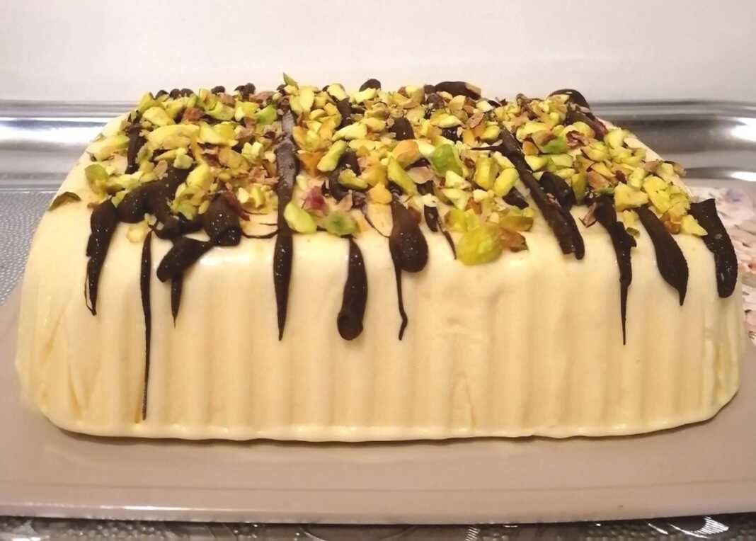 pagoto Ενα παγωτό Σεμιφρέντο με κρεμώδη υφή, γαρνιρισμένη με λιωμένη σοκολάτα και ψιλοκομμένα φιστίκια.