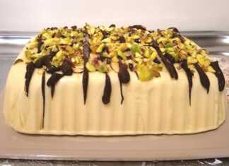 Ενα παγωτό Σεμιφρέντο με κρεμώδη υφή, γαρνιρισμένη με λιωμένη σοκολάτα και ψιλοκομμένα φιστίκια.