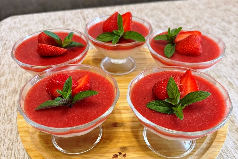 panakota zele fraoulas01 Πέντα γυάλινα ποτήρια με στρώσεις παννακότας (κάτω) και κόκκινου ζελέ φράουλας (πάνω), διακοσμημένα με φρέσκες φράουλες.