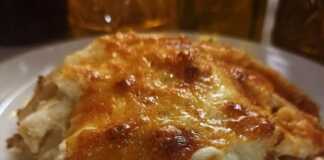 Παστίτσιο της Νοικοκυράς Ένα κομμάτι χρυσαφένιο παστίτσιο, με αφράτη, ροδοκόκκινη μπεσαμέλ από πάνω.