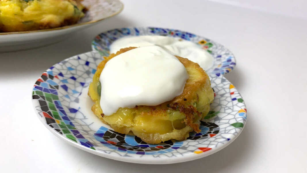 Ένας πατατοκεφτες τηγανητός με κορκούτι και απο πάνω μια κουταλια γιαουρτι