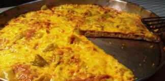 Πίτσα Εξπρές με Υγρή Ζύμη (Χωρίς Ζύμωμα, Χωρίς Αναμονή!) Μια φρεσκοψημένη, λαχταριστή πίτσα με χρυσαφένια κρούστα, λιωμένο τυρί, μπέικον και πιπεριές, πάνω σε ένα ταψί.