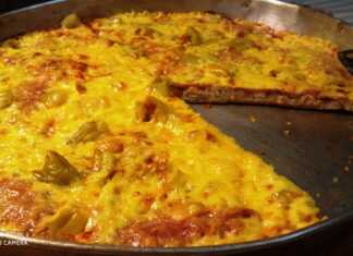 Μια φρεσκοψημένη, λαχταριστή πίτσα με χρυσαφένια κρούστα, λιωμένο τυρί, μπέικον και πιπεριές, πάνω σε ένα ταψί.