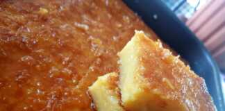 Πορτοκαλόπιτα με Φύλλο Κρούστας και Γιαούρτι Ένα ταψί πορτοκαλόπιτας, που δείχνει την πορώδη υφή του γλυκού και το χρυσαφένιο του χρώμα, περιχυμένο με σιρόπι.