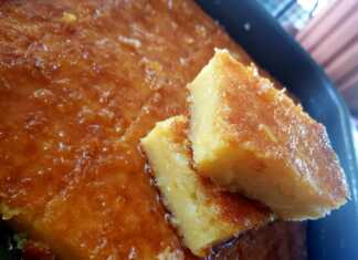 Ένα ταψί πορτοκαλόπιτας, που δείχνει την πορώδη υφή του γλυκού και το χρυσαφένιο του χρώμα, περιχυμένο με σιρόπι.