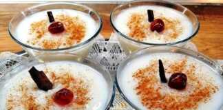 Μπολάκια με ζεστό, κρεμώδες ρυζόγαλο πασπαλισμένο με κανέλα, τοποθετημένα σε ξύλινη επιφάνεια.