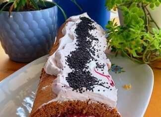 ρολό σοκολατένιο παντεσπάνι γεμιστό με λευκή κρέμα και κόκκινο γλυκό κεράσι, σε ένα πιάτο.