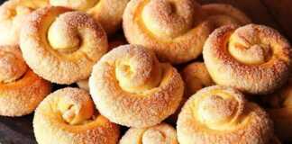 Χρυσαφένια, ζαχαρωμένα κουλουράκια σε σχήμα σαλιγκαριού σε ένα ταψί, φρεσκοψημένα.