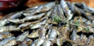 Ψητές σαρδέλες τοποθετημένες σε δίσκο, έτοιμες για σερβίρισμα.