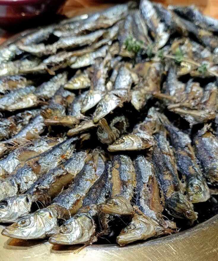 Ψητές σαρδέλες τοποθετημένες σε δίσκο, έτοιμες για σερβίρισμα.