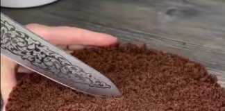 Μία σοκολατένια τούρτα χωρίς ψήσιμο, με σκούρα βάση μπισκότου και ανοιχτόχρωμη κρεμώδη στρώση, πασπαλισμένο με θρυμματισμένα μπισκότα.