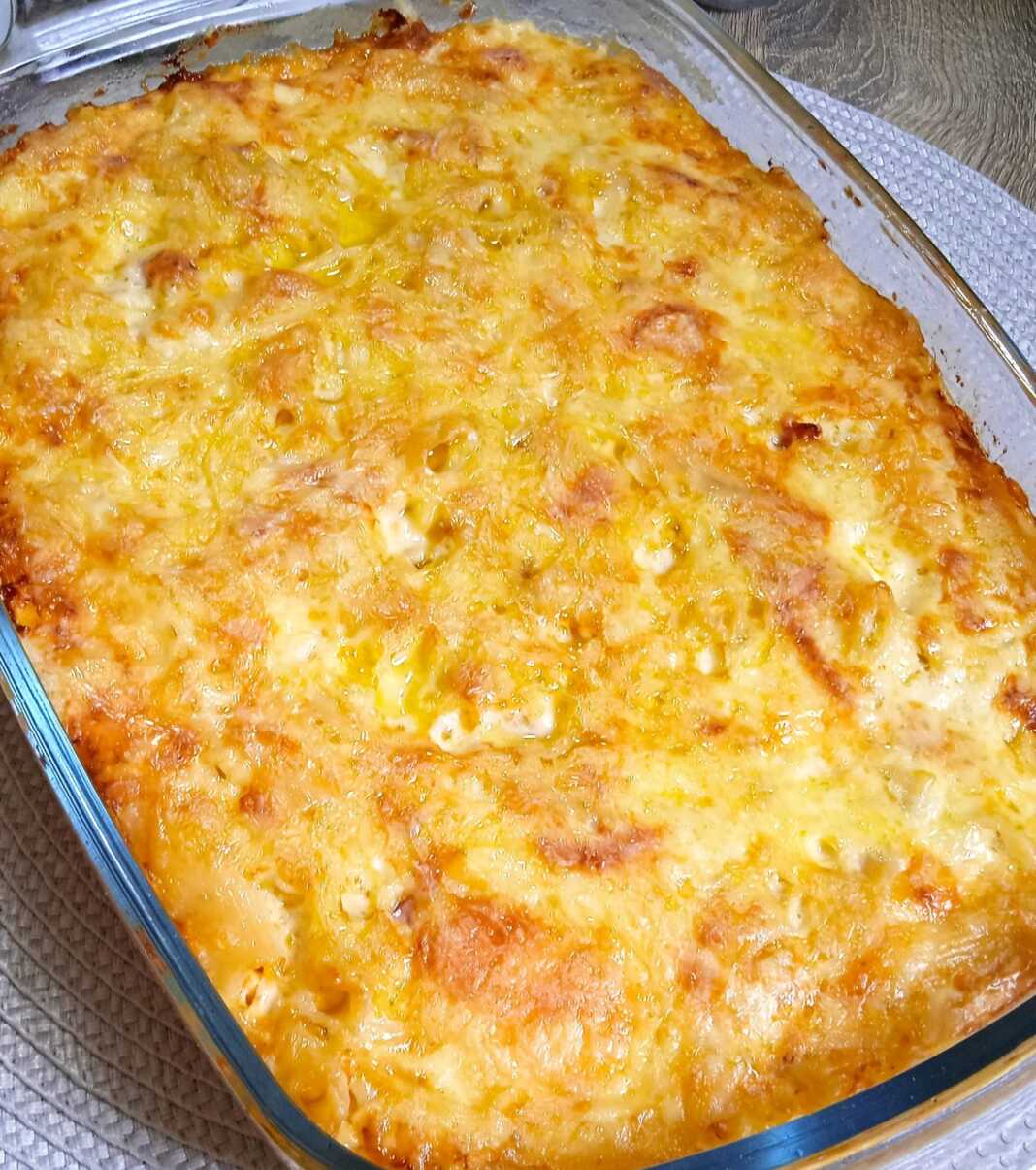 Ένα ταψί με χρυσαφένιο, ψημένο σουφλέ μακαρονιών με λιωμένο τυρί στην κορυφή.