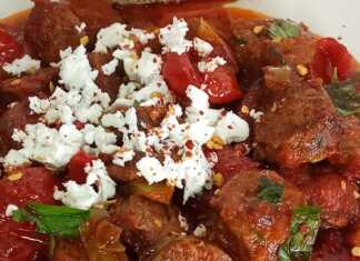 Ένα πιατο γεμάτο με κόκκινο, ζουμερό σπετσοφάι, με κομμάτια λουκάνικου, πιπεριές και ντομάτα.