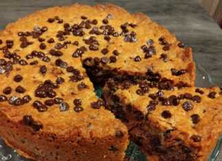 Μια στρογγυλή τάρτα μπισκότο γεμιστή με Nutella, πασπαλισμένη με σταγόνες σοκολάτας, σερβιρισμένη χλιαρή με μια μπάλα παγωτό.