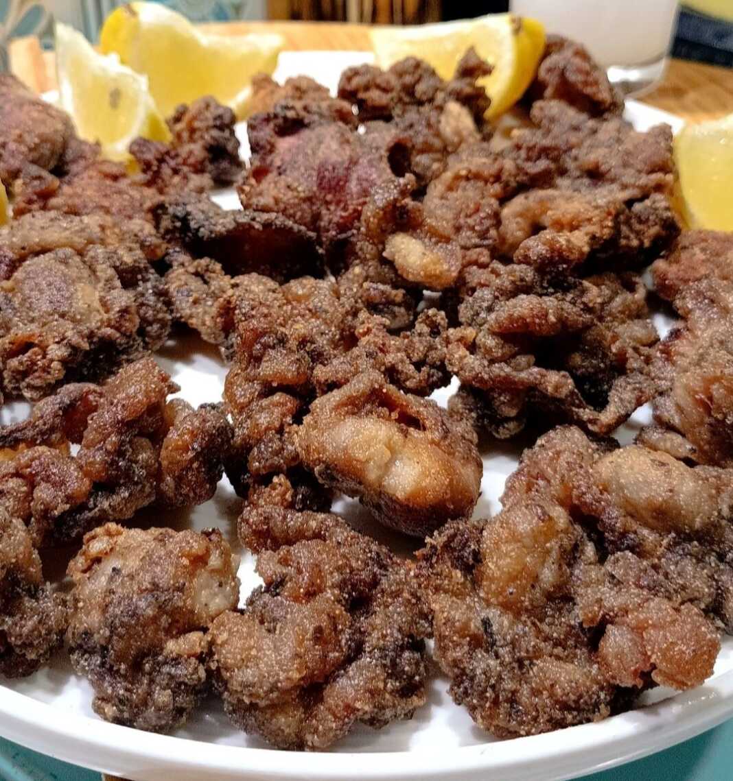 tiganita glikadia Ένα πιάτο γεμάτο με χρυσαφένια, τηγανητά κομμάτια γλυκαδιών, πασπαλισμένα με ρίγανη, έτοιμα για σερβίρισμα.