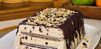 Μία πλούσια, παγωμένη τούρτα παγωτό καπουτσίνο, πασπαλισμένη με σκόνη κακάο, κομμένη σε φέτες σε μια πιατέλα.