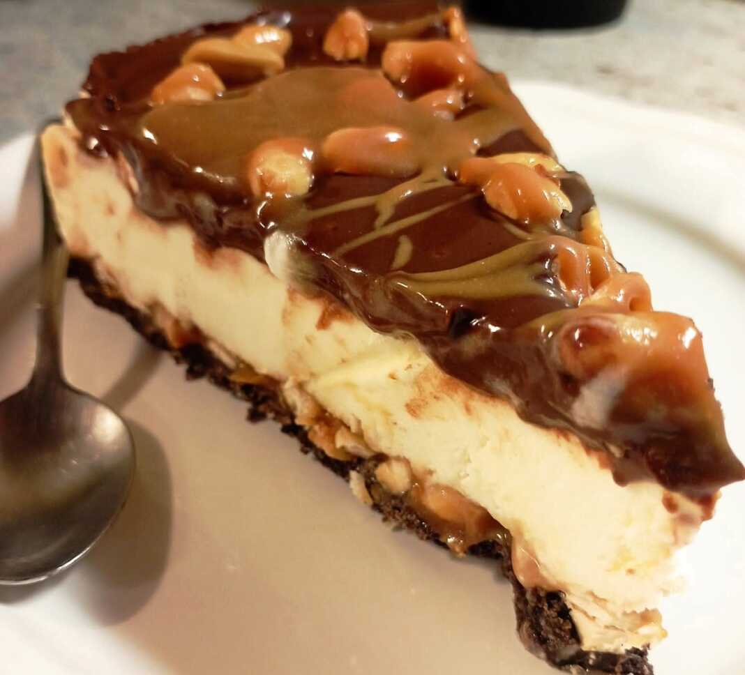 torta snickers Ενα κομμάτι τούρτα παγωτό με στρώσεις σοκολατένιας βάσης, κρεμώδους παγωτού, σάλτσας καραμέλας με φυστίκια, και γλάσου σοκολάτας από πάνω.