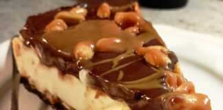 Ενα κομμάτι τούρτα παγωτό με στρώσεις σοκολατένιας βάσης, κρεμώδους παγωτού, σάλτσας καραμέλας με φυστίκια, και γλάσου σοκολάτας από πάνω.