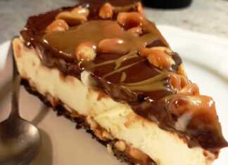 Ενα κομμάτι τούρτα παγωτό με στρώσεις σοκολατένιας βάσης, κρεμώδους παγωτού, σάλτσας καραμέλας με φυστίκια, και γλάσου σοκολάτας από πάνω.