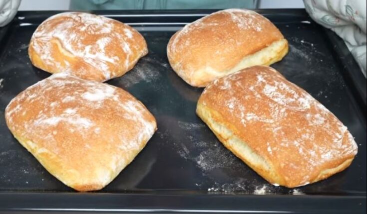 έσσερις φρεσκοψημένες τσιαμπάτες με χρυσαφένια, τραγανή κρούστα και αλευρωμένη επιφάνεια, τοποθετημένες σε σχάρα ψησίματος.