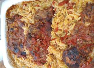 Ένα ταψί με λαχταριστό γιουβέτσι, με χρυσαφένιο κριθαράκι και κομμάτια χοιρινού κρέατος μέσα σε κόκκινη σάλτσα ντομάτας.