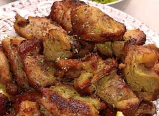 Μια μερίδα Χοιρινή τηγανιά με ροδισμένα κομμάτια κρέατος σε ένα πιάτο, με πράσινη σαλάτα στο πλάι.