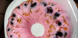 Δροσερό Γιαούρτι με Ζελέ, Φρούτα και Άρωμα Δυόσμου Ένα μπολ γεμάτο με ροζ γλυκό γιαούρτι και ζελέ, αναμεμειγμένο με κόκκινα κεράσια, κομματάκια νεκταρινιού, και πράσινα φυλλαράκια δυόσμου.