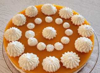 Ένα ολόκληρο τσιζκέικ χωρίς ψήσιμο με ροδάκινα, γαρνιρισμένο με σαντιγί, έτοιμο για σερβίρισμα.