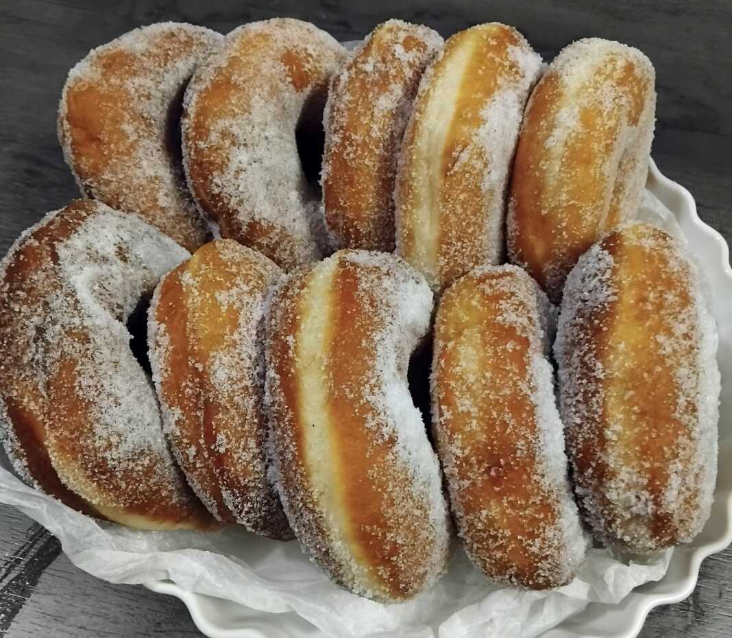 Αφράτοι λουκουμάδες με ζάχαρη άχνη σε πιατέλα, έτοιμοι για σερβίρισμα