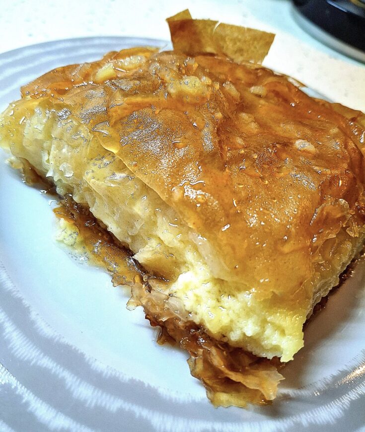 Κομμάτι από γαλακτομπούρεκο, αναδεικνύοντας την αφράτη κρέμα και τα τραγανά φύλλα.