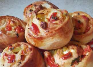 Ατομικά πιτσάκια : Η Συνταγή που θα Λατρέψεις! Κομμένο ατομικό πιτσάκι προζύμι, με ορατή τη γέμιση από φέτα, πιπεριά και ντομάτα.