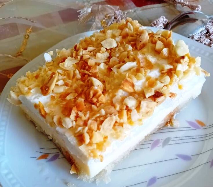 Ένα Κομματι Δροσερό Γλυκό Ψυγείου με Φρυγανιές, στρωμένο σε πυρέξ, γαρνιρισμένο με αμύγδαλα