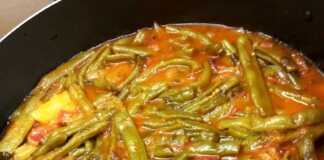 Μία κατσαρόλα με λαχταριστά φασολάκια με μελιτζάνες, πλούσια κόκκινη σάλτσα, έτοιμο για σερβίρισμα.