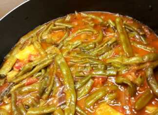 Μία κατσαρόλα με λαχταριστά φασολάκια με μελιτζάνες, πλούσια κόκκινη σάλτσα, έτοιμο για σερβίρισμα.