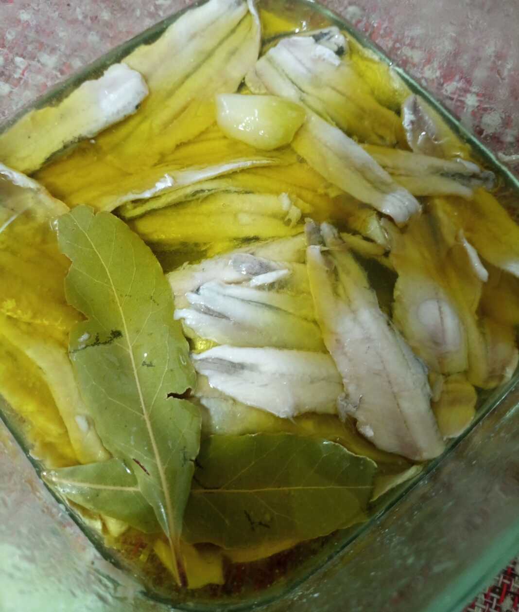 gavros ksidatos Γυάλινο μπολ με έτοιμο Γαύρο Ξυδάτο, καλυμμένο με λάδι και φέτες σκόρδου.