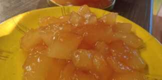 Κοντινό πλάνο σε ένα κουταλάκι με Γλυκό του Κουταλιού Πεπόνι, που αναδεικνύει το παχύρρευστο σιρόπι και τα διάφανα κομμάτια φρούτου.