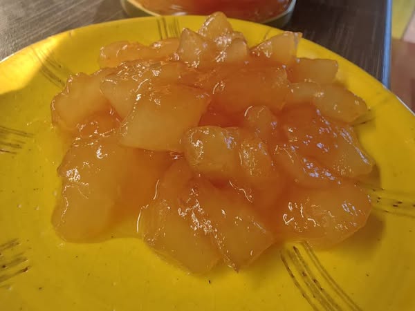 gliko peponi Κοντινό πλάνο σε ένα κουταλάκι με Γλυκό του Κουταλιού Πεπόνι, που αναδεικνύει το παχύρρευστο σιρόπι και τα διάφανα κομμάτια φρούτου.