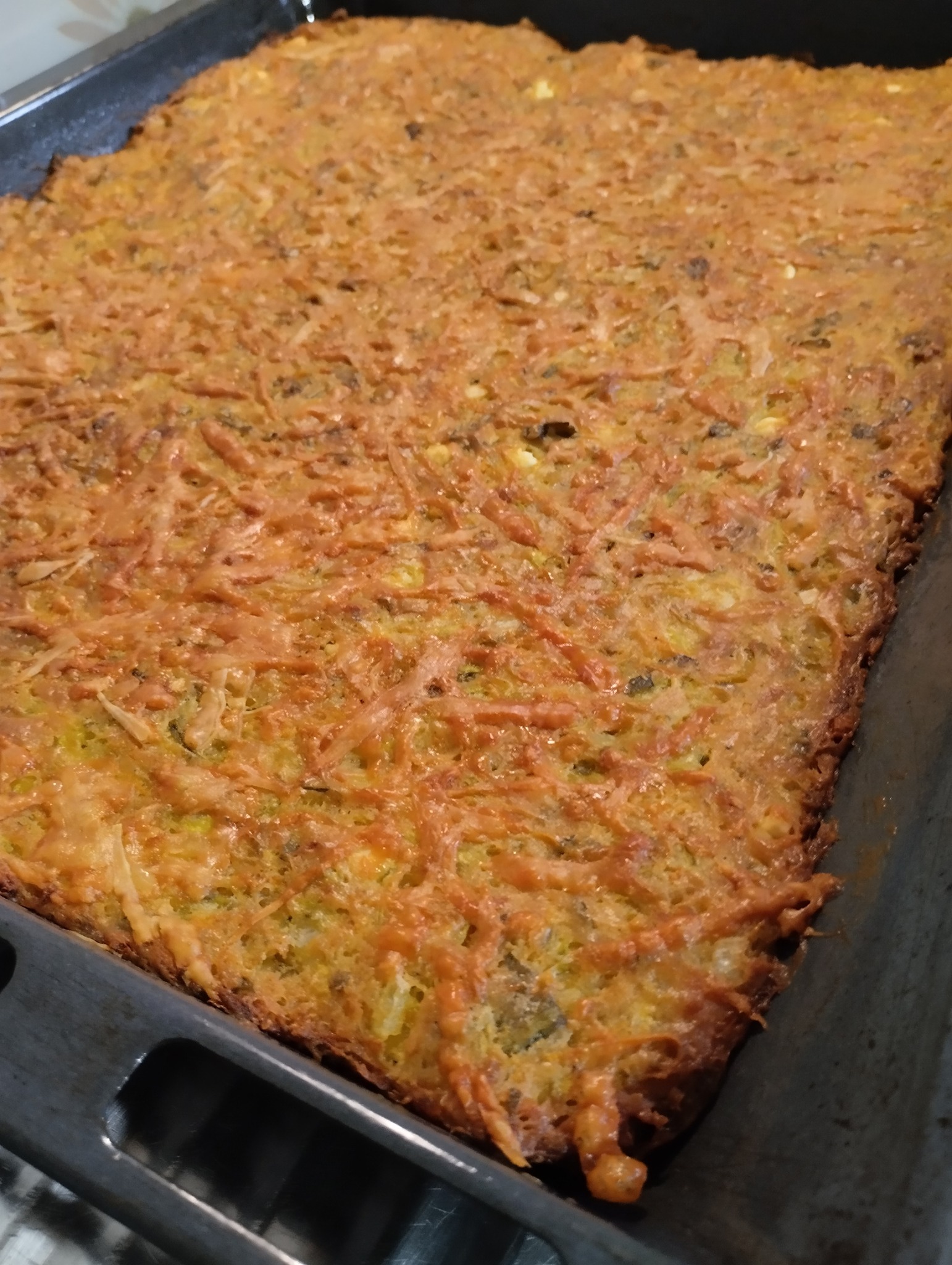 Παραδοσιακή κολοκυθόπιτα χωρίς φύλλο (μπατζίνα), κομμένη σε ταψί