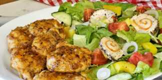 Πιάτο με σερβιρισμένο κοτόπουλο λεμονάτο και φρέσκια πράσινη σαλάτα.